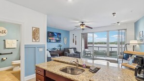A modern kitchen with a granite countertop, a built-in sink, and a ceiling fan. - Delton Dawn - Luxury at Delton Grand (Wisconsin Dells)