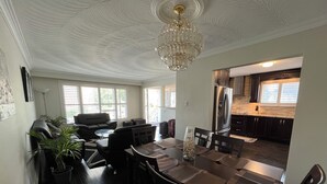 A dining area with a table set for four, a chandelier, and a view into the kitchen. - Spacious 3BR Toronto Home Near Downtown (Toronto)
