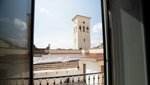A view from a balcony with a metal railing, a building with a tower, and a clear sky. - Modern Suite and Open Space Bedroom• 200 meters from Sea • into Historic Center (Salerno)