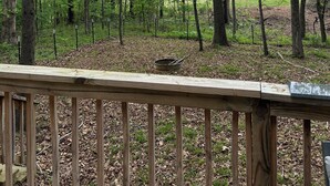 A wooden deck with a view of a forested area.