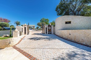 A stone pathway leading to a villa entrance with a clock and a sign that reads 'Villa Arthur.' - Luxurious Villa Arthur in Corfu | Heated Pool & Jacuzzi, Sea Views, Outdoor BBQ (Kassiopi)