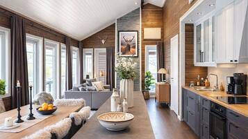 A modern kitchen with dark cabinets, a wooden countertop, and a dining area with a large table and chairs.