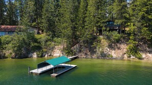 A lakeside cabin with a dock and a covered boat ramp. - Waterfront Sandbar Point w/ Dock Access & Nearby Activities (Hayden)