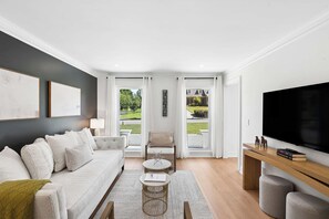 A modern living room with a sofa, coffee table, and TV stand.