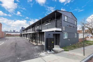 A two-story building with a fire escape, a garage door, and a keypad box. - Cozy Studio Walkable OTE and Downtn with Parking (Columbus)