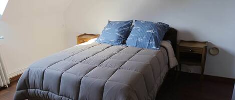 A bedroom with a bed, two nightstands, and a window.