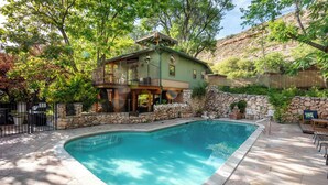 A house with a pool, stone walls, and a balcony. - Creekside retreat + hot tub near Sedona (Cornville)