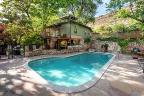 A house with a pool, stone walls, and a balcony. - Creekside retreat + hot tub near Sedona (Cornville)