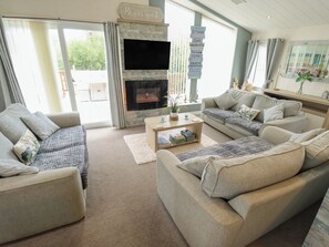 A living room with a fireplace, sofas, a coffee table, and a sign above the fireplace.