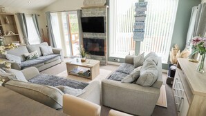 Una sala de estar acogedora con chimenea, un sofá, una mesa de centro y un televisor.