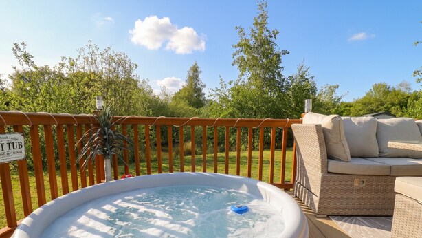 Un jacuzzi en una terraza de madera con un cartel que indica 'TUB TUBING OPCIONAL'.