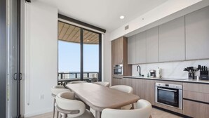 Una cucina moderna con zona pranzo, ampie finestre e vista sulla città.
