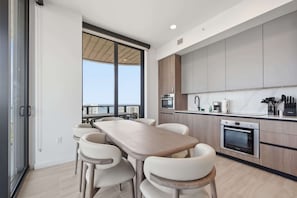 Eine moderne Küche mit Essbereich, großen Fenstern und Blick auf die Stadt.