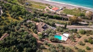 An aerial view of a coastal property with a swimming pool, a red-roofed building, and a beach. - Sea Pool and Relax Cefalù (Cefalù)