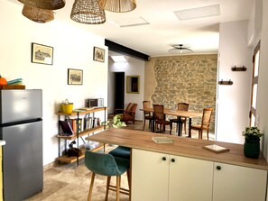 A kitchen with a refrigerator, dining table, chairs, and a potted plant. - Single-storey house in the Capucins district - near Paicherou swimming pool and Cité (Carcassonne)