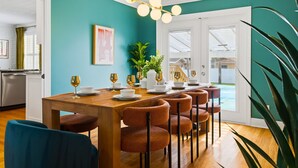 Un comedor con una mesa de madera, seis sillas y una lámpara de araña.