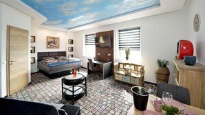 A room with a bed, desk, chair, and a dining table.