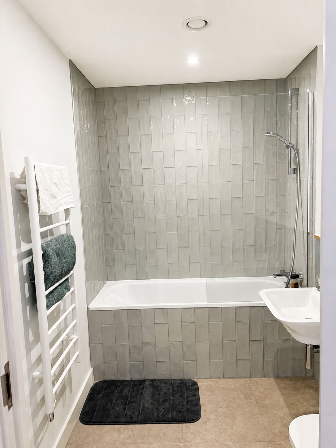 A modern bathroom with a bathtub, a shower, and a sink.
