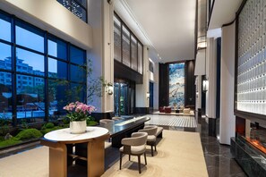 A modern lobby with a seating area, a large window, and a decorative wall.