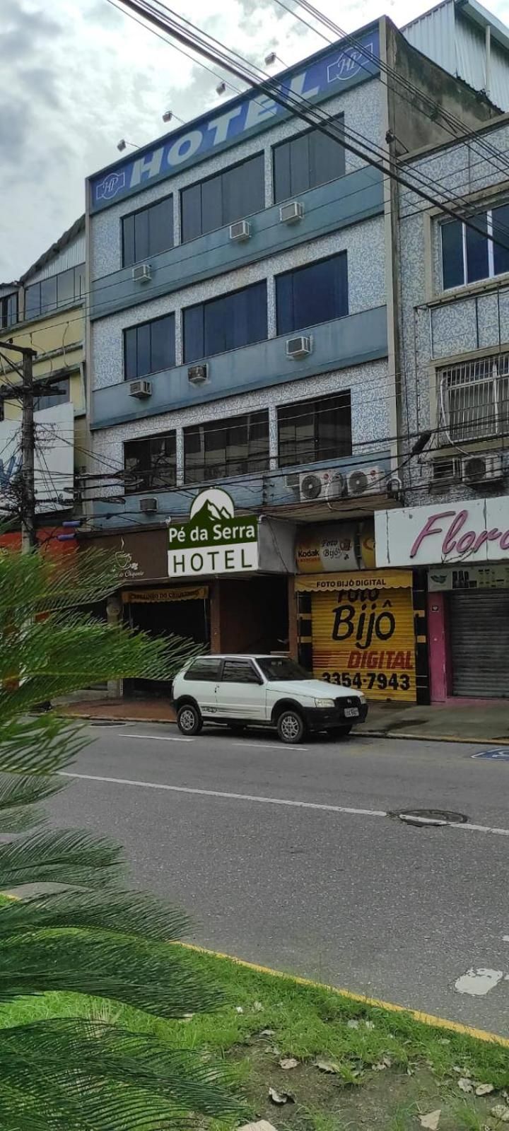 A hotel building with a sign for 'Pé da Serra Hotel' and a digital photo shop.
