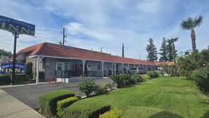 A Wine Country Inn with a red-tiled roof, a covered parking area, and well-maintained landscaping.