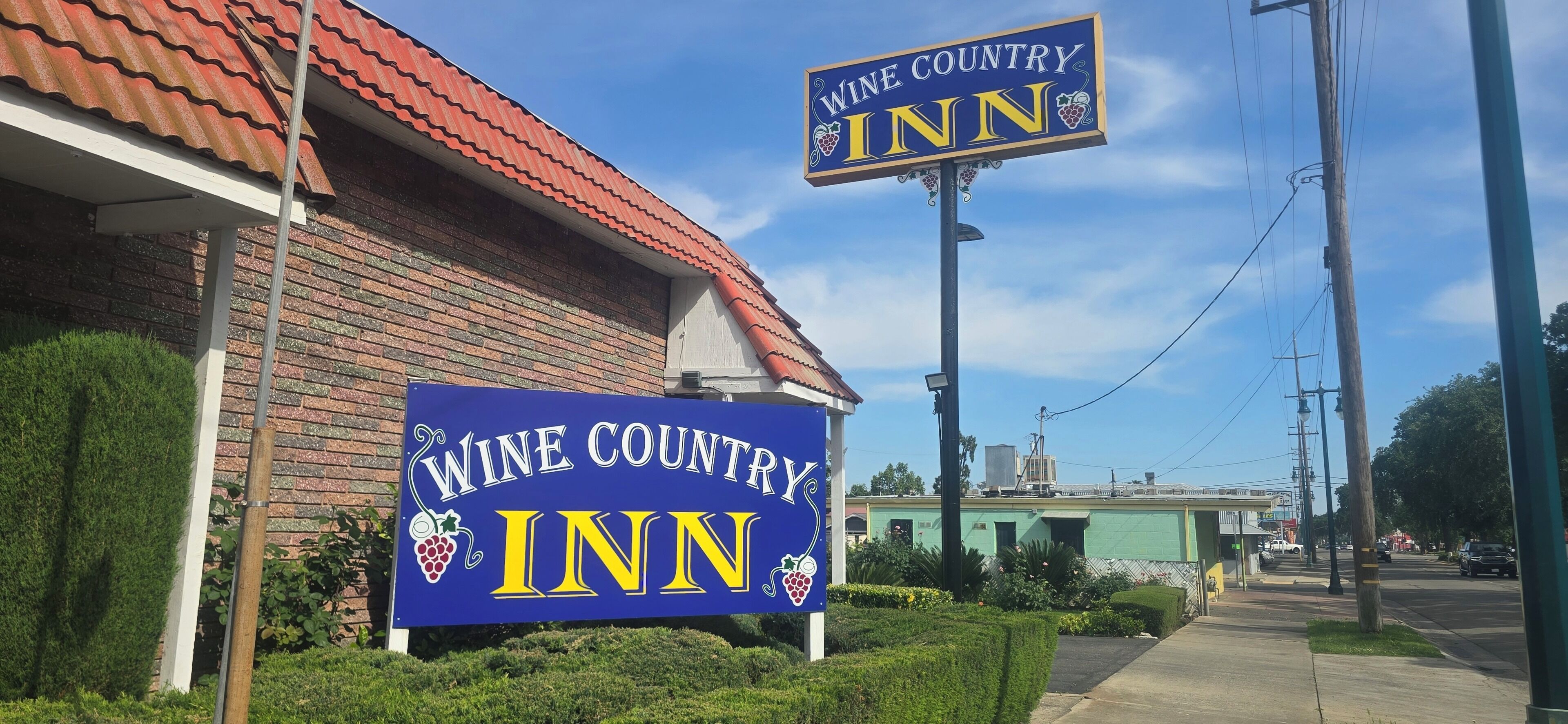 Un edificio con un letrero que dice 'Wine Country Inn' y un techo de tejas rojas.