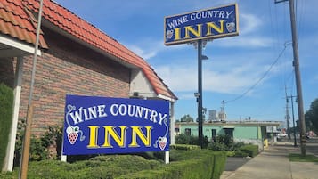 Un edificio con un letrero que dice 'Wine Country Inn' y un techo de tejas rojas.