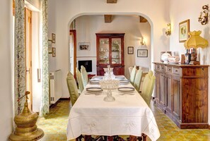 A dining room with a long table set for six, a cabinet with glass doors, and a decorative lamp. - Villa Seraia - Mascali (Mascali)