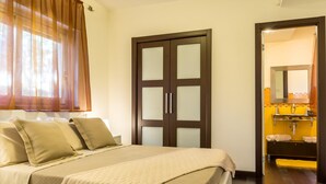 Ein Hotelzimmer mit Bett, Schrank und Bad mit Spiegel und Waschbecken.