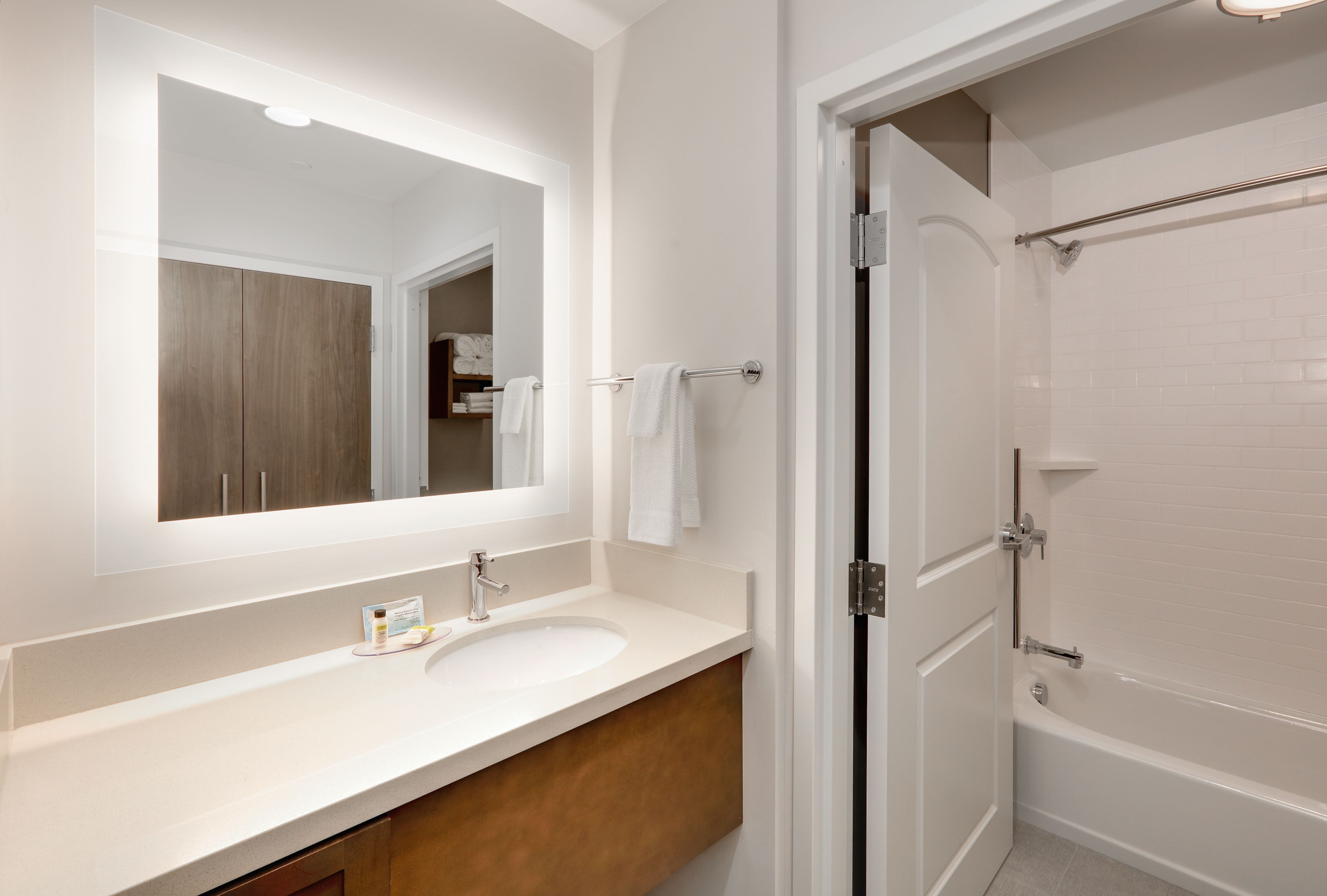 Une salle de bain avec un lavabo blanc, un miroir et une douche.