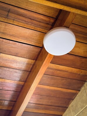 Une structure de plafond en bois avec un luminaire circulaire.