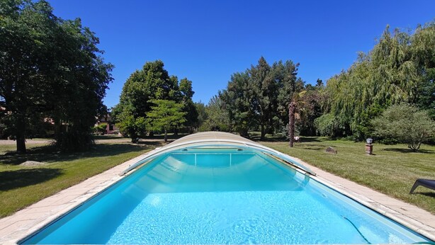 A rectangular swimming pool with a tiled deck, surrounded by trees and grass. - Country house with swimming pool  (Savenès)