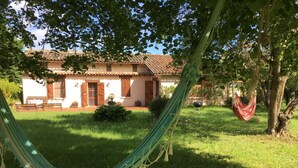 A house with a tiled roof, a hammock, and a small garden. - Country house with swimming pool  (Savenès)