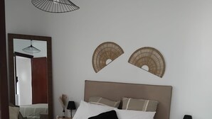 A bedroom with a bed, bedside tables, a nightstand, a mirror, and wall decorations. - Sea and Mountains, comfortable country house full of charm 6 minutes from the sea (Ventiseri)
