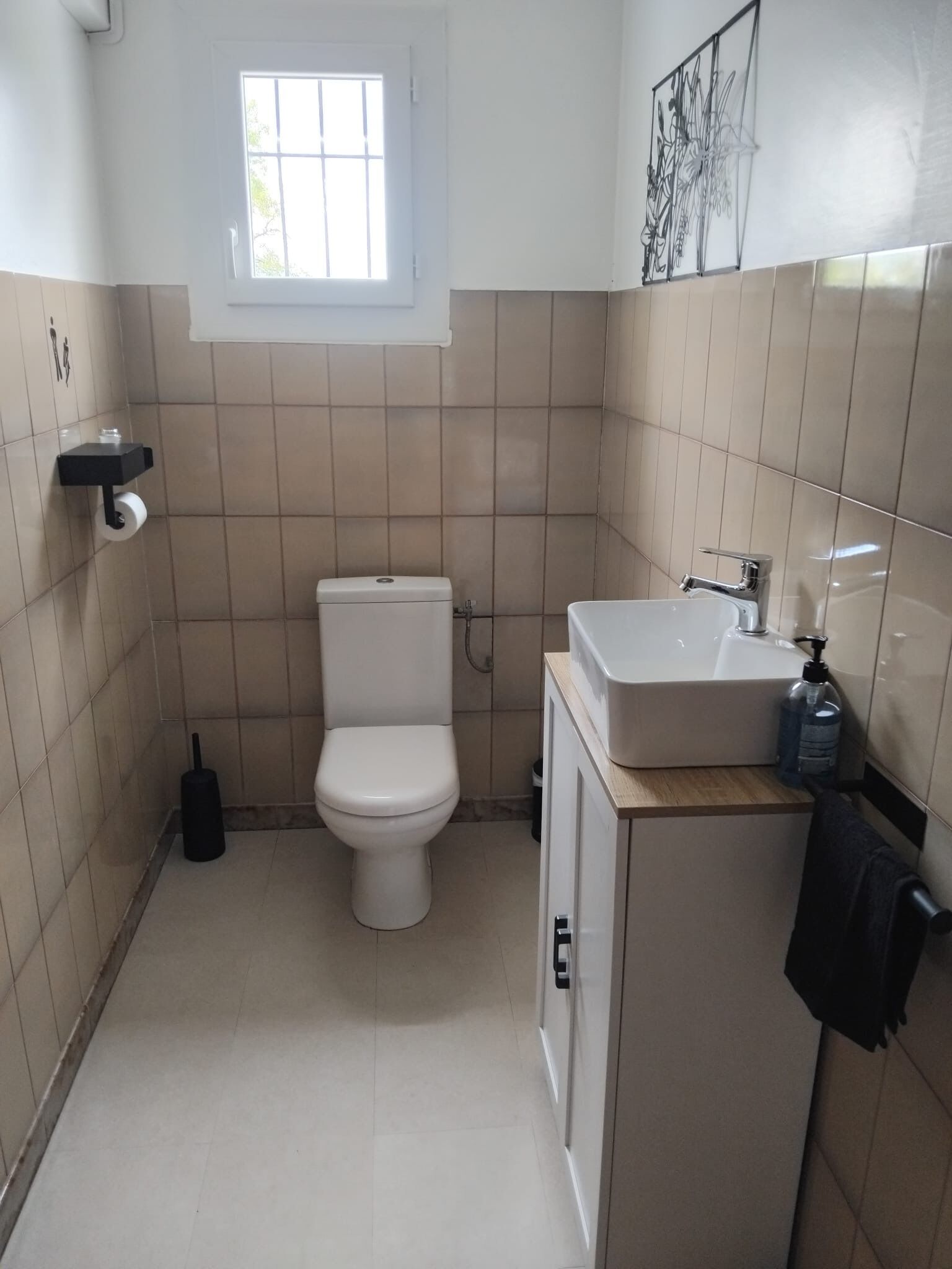 Un bagno piccolo e pulito con servizi igienici, lavandino e finestra.