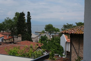 A coastal town with traditional architecture, a view of the sea, and a prominent church steeple.