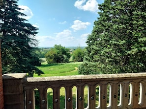 A stone balustrade with a view of a green landscape, trees, and a clear sky. - Le Gite de Douine (Avignonet-Lauragais)