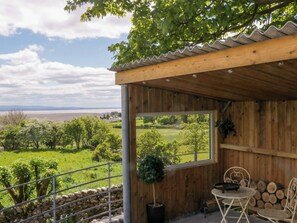 A wooden cabin with a balcony overlooking a scenic landscape. - Little Hut (Grange-over-Sands)