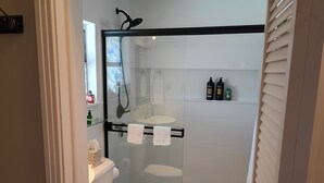 Ein modernes Badezimmer mit einer Duschkabine, einer Toilette und einem Waschbecken.