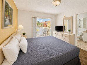 A hotel room with a bed, a TV, a balcony with a view, and a bathroom. - Easy family stay with resort pool (Kissimmee)
