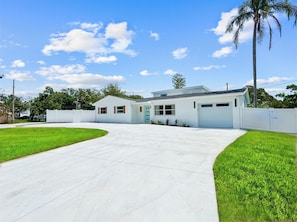 Ein zweistöckiges Haus mit Garage, Auffahrt und gepflegtem Rasen.