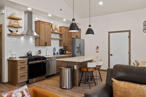 A modern kitchen with wooden cabinets, a stainless steel stove, and pendant lighting. - rand New Modern Western Home in Downtown Red Lodge (Red Lodge)