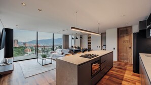 Una cucina moderna con isola centrale, ampie finestre e vista sulla città.
