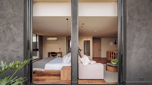 Un ambiente moderno con un letto, un'area salotto e una scala che conduce a un'altra stanza.
