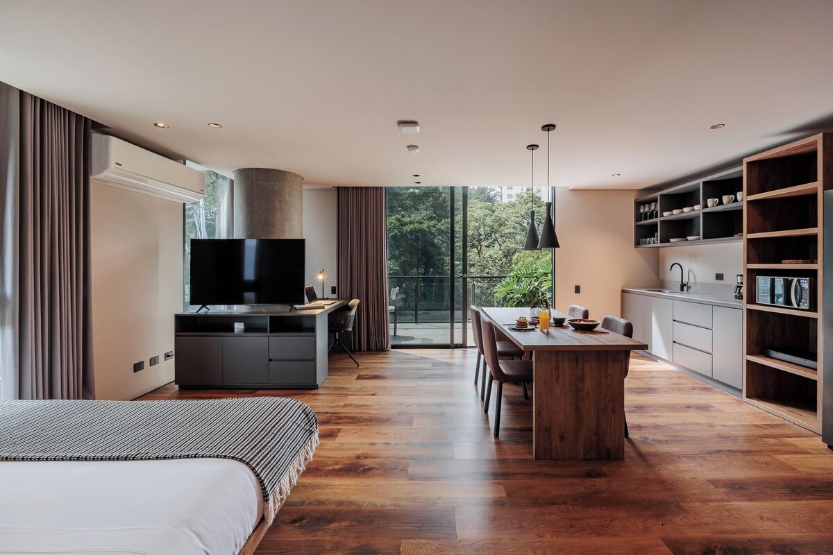 Un appartamento moderno con una grande TV, un'area pranzo e una cucina.