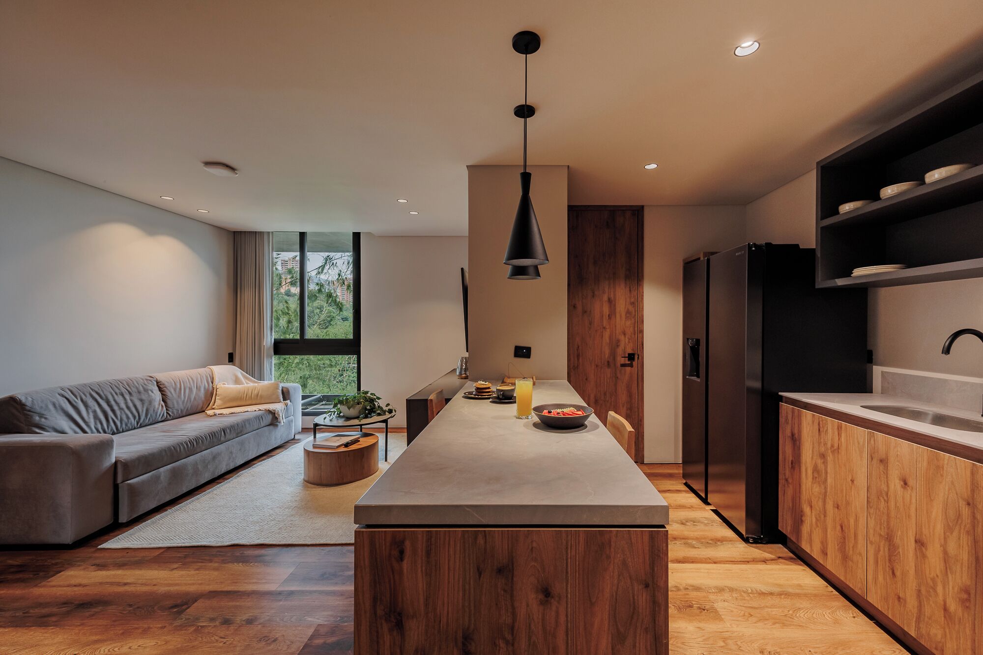 Una cocina moderna con una isla central, armarios de madera y un horno empotrado.