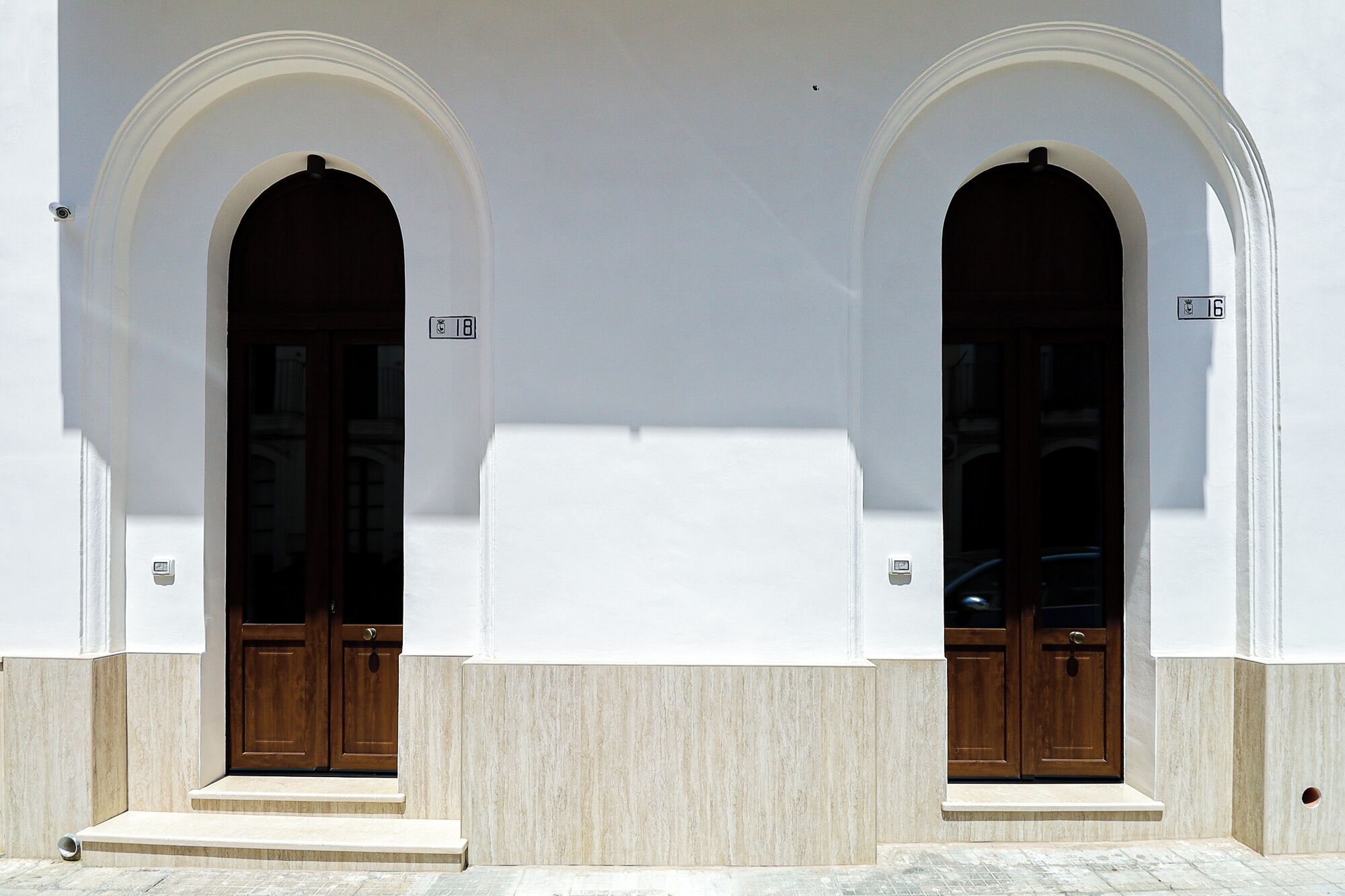 Un edificio con due porte ad arco, ognuna con il simbolo del numero sopra.