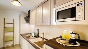 Eine Küche mit Holzausstattung, einer Mikrowelle, einem Toaster und einer Kaffeemaschine auf der Arbeitsfläche.