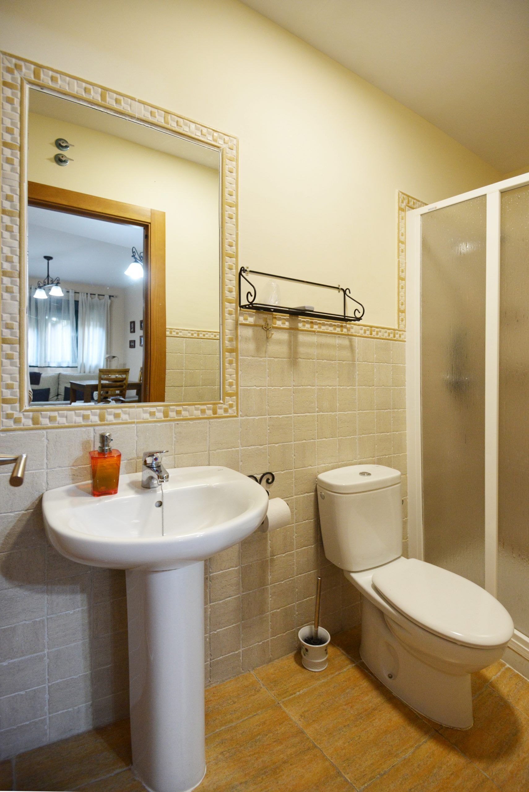 Un baño con lavamanos, inodoro y espejo.