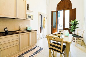 Una cucina con mobili in legno, un forno a microonde, una macchina per il caffè e un tavolo con sedie.